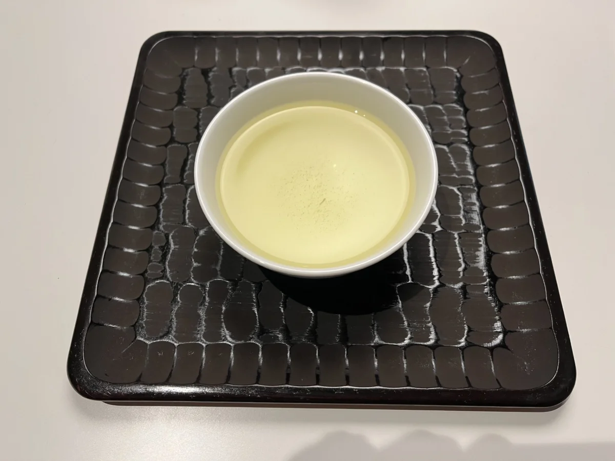 二煎目の水色。一煎目より濃い黄色で、中央に細かい粉が浮いている