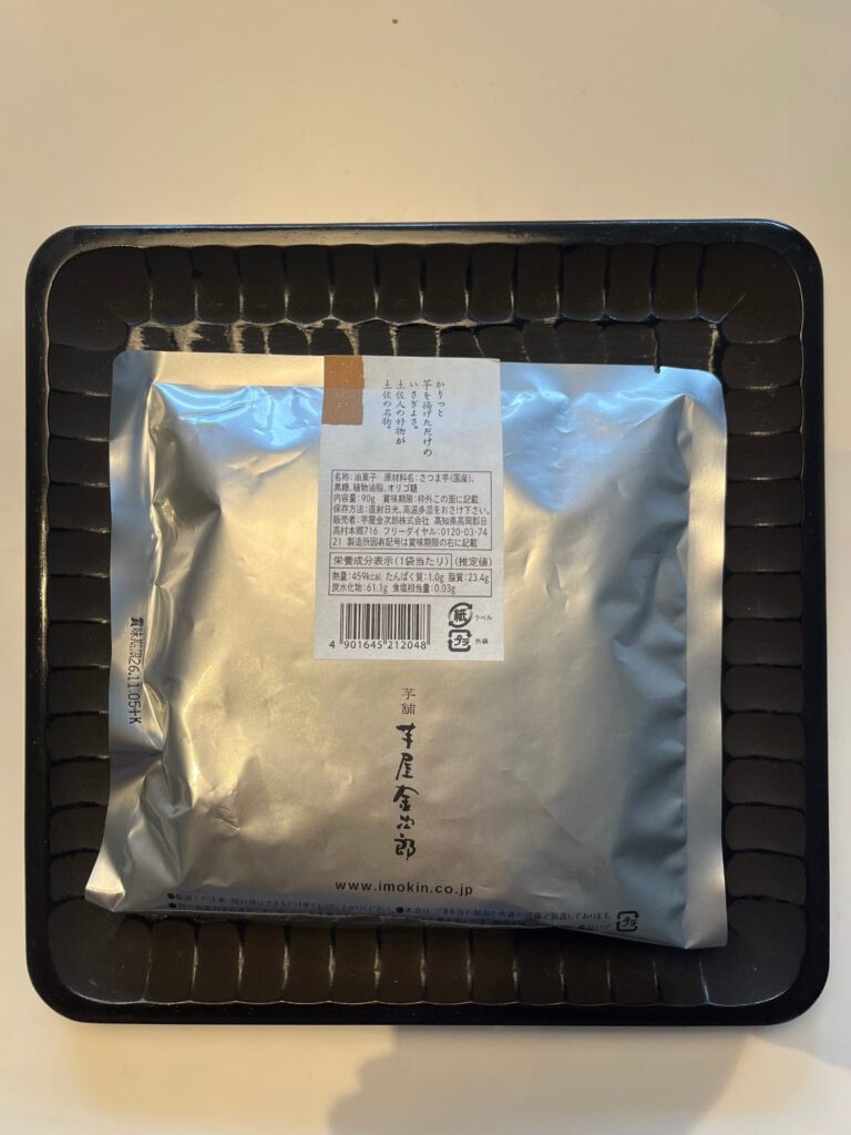 芋屋金次郎「黒糖 芋けんぴ」の袋の裏。原材料はさつま芋（国産）、黒糖、植物油脂、オリゴ糖。内容量90g。販売者は高知県高岡郡日高村の芋屋金次郎株式会社